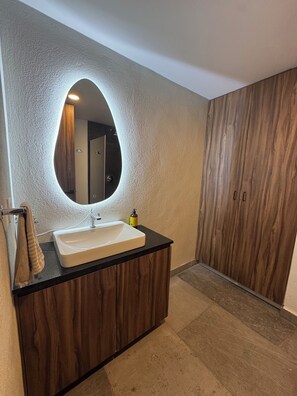 A bathroom with a white sink, wooden cabinets, a large mirror, and a towel rack. - Alba by Pardela (Guadalajara)