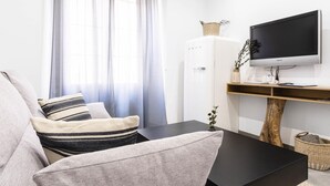 Ein modernes Wohnzimmer mit einer Couch, einem Couchtisch, einem Flachbildfernseher und einem Holz-TV-Möbel.