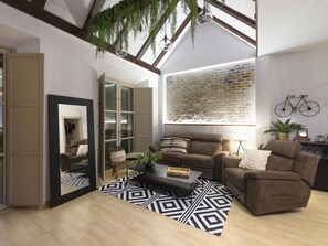 A modern living room with a sofa, a coffee table, and a patterned rug.