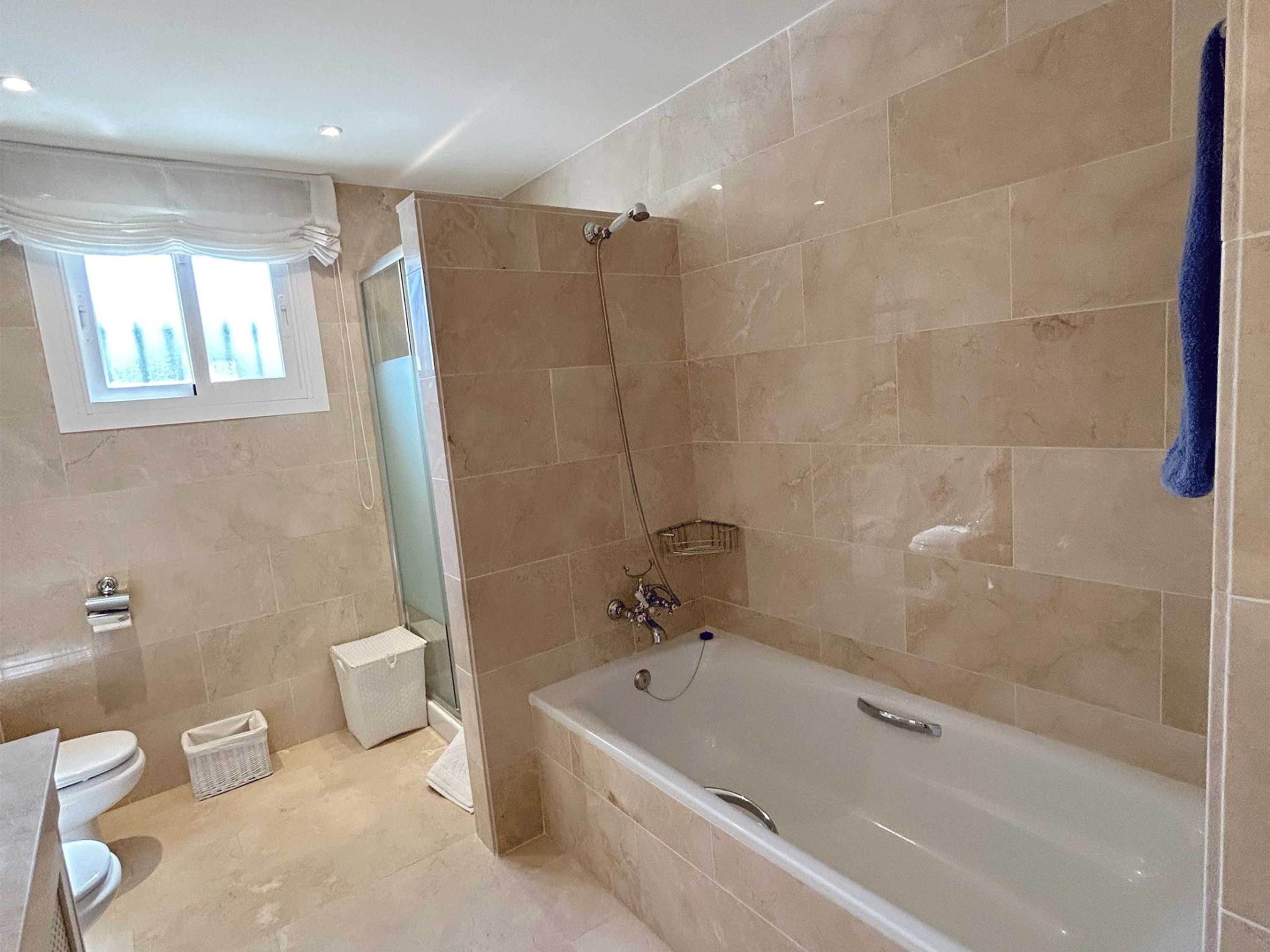 Ein modernes Badezimmer mit Badewanne, Dusche und Toilette.
