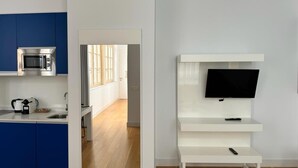 Una cocina moderna con armarios azules, un microondas y una tetera.