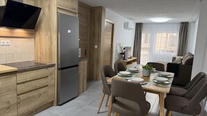 A modern kitchen with wooden cabinetry, a stainless steel refrigerator, and a built-in oven.