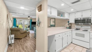 A compact kitchen with white cabinets, a built-in microwave, and an oven.