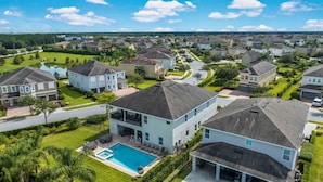 A residential area with modern houses, a swimming pool, and well-maintained lawns. - The Enchanted Collection: Burma Manor (Kissimmee)