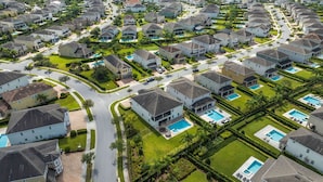 A residential area with multiple houses, each with a private pool and well-maintained lawns. - The Enchanted Collection: Burma Manor (Kissimmee)