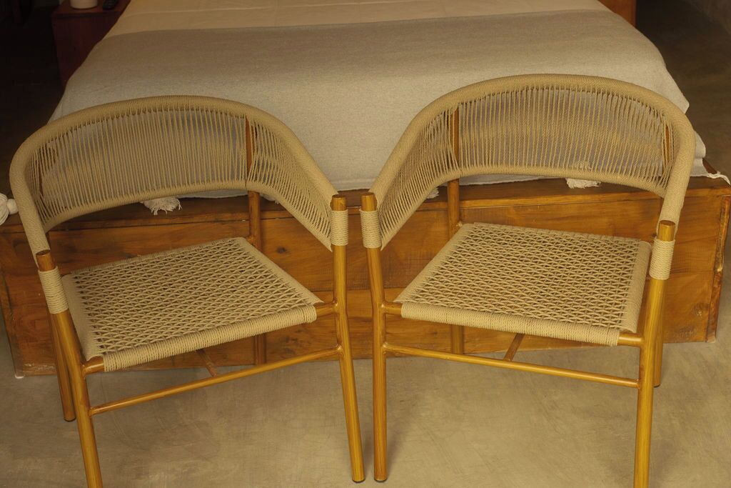 Two wicker chairs with woven seats and backs, placed on a wooden floor.