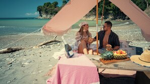 A beach scene with a tent, a table with food, and a bottle. - Dar Lamia Boutique Hotel (Quepos)