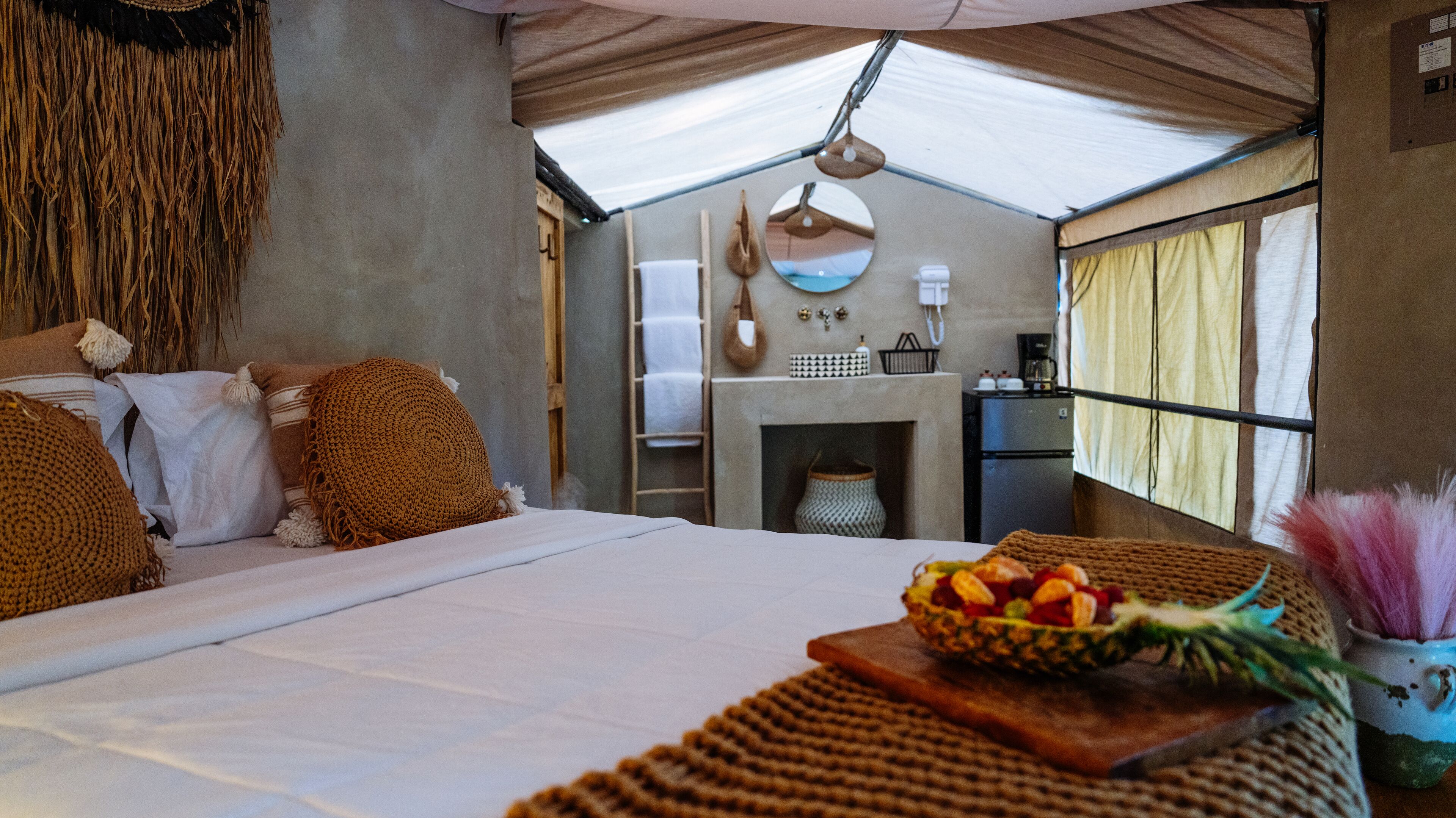 A cozy bedroom with a large bed, a small fireplace, and a breakfast tray on the nightstand.