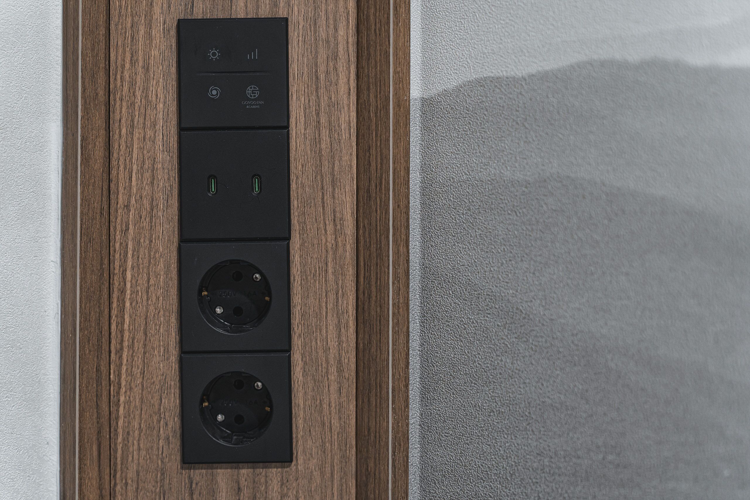 A wall-mounted electrical panel with two switches, two USB ports, and two power sockets.