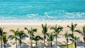 A beach with clear turquoise water, sandy shore, and palm trees. - Luxurious 4,198 sq ft OCEANFRONT  SUITE. 3 bdrm, 3.5 bath, SPRING BREAK 2026 (Cabo San Lucas)