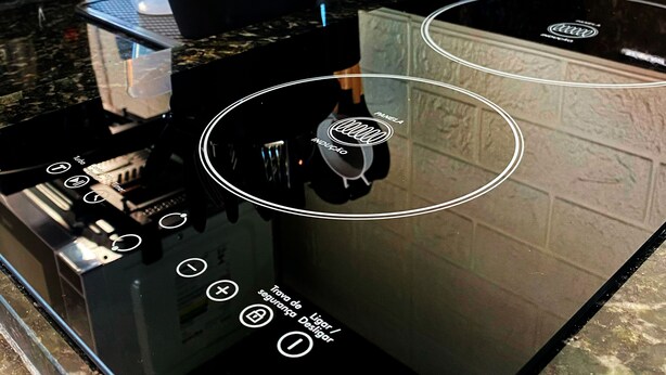 A kitchen with a black countertop, a coffee machine, and various utensils.
