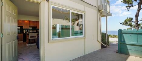 A house with a large sliding glass door leading to a kitchen and dining area.
