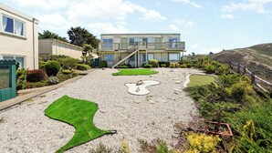 Een modern gebouw met een plat dak, meerdere ramen en een balkon.