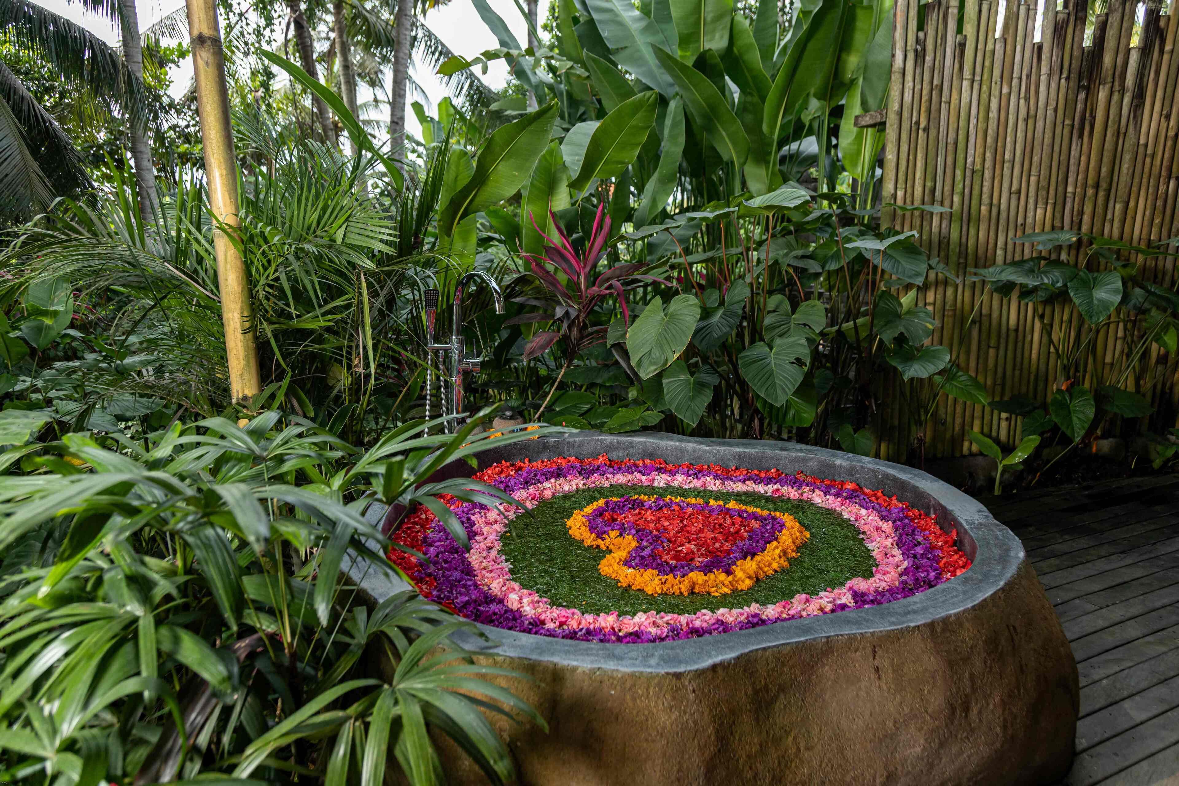 Un bac à fleurs circulaire en pierre, orné d’un motif floral.
