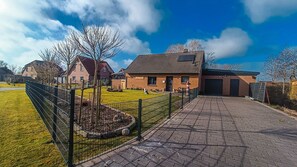 Un barrio residencial con casas, un camino pavimentado y un patio cercado.