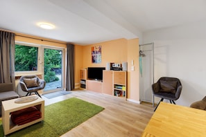 Un salon moderne comprenant un canapé, une table basse, un téléviseur et une bibliothèque.