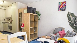 A compact living space with a dining area, kitchenette, and a cozy seating area. - BeKb-Gebäude Studio No02 by Interhome (Wengen)