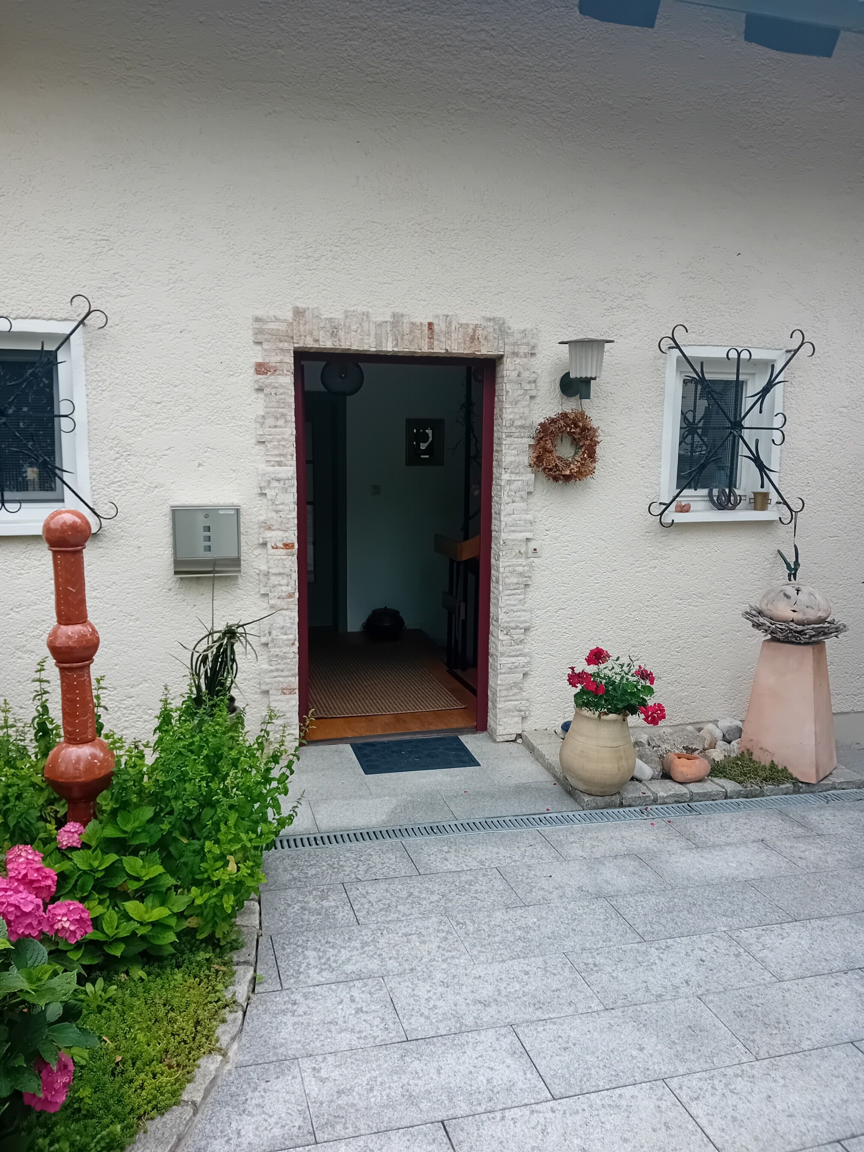 A building entrance with a door, a small window, and a wall-mounted wreath.