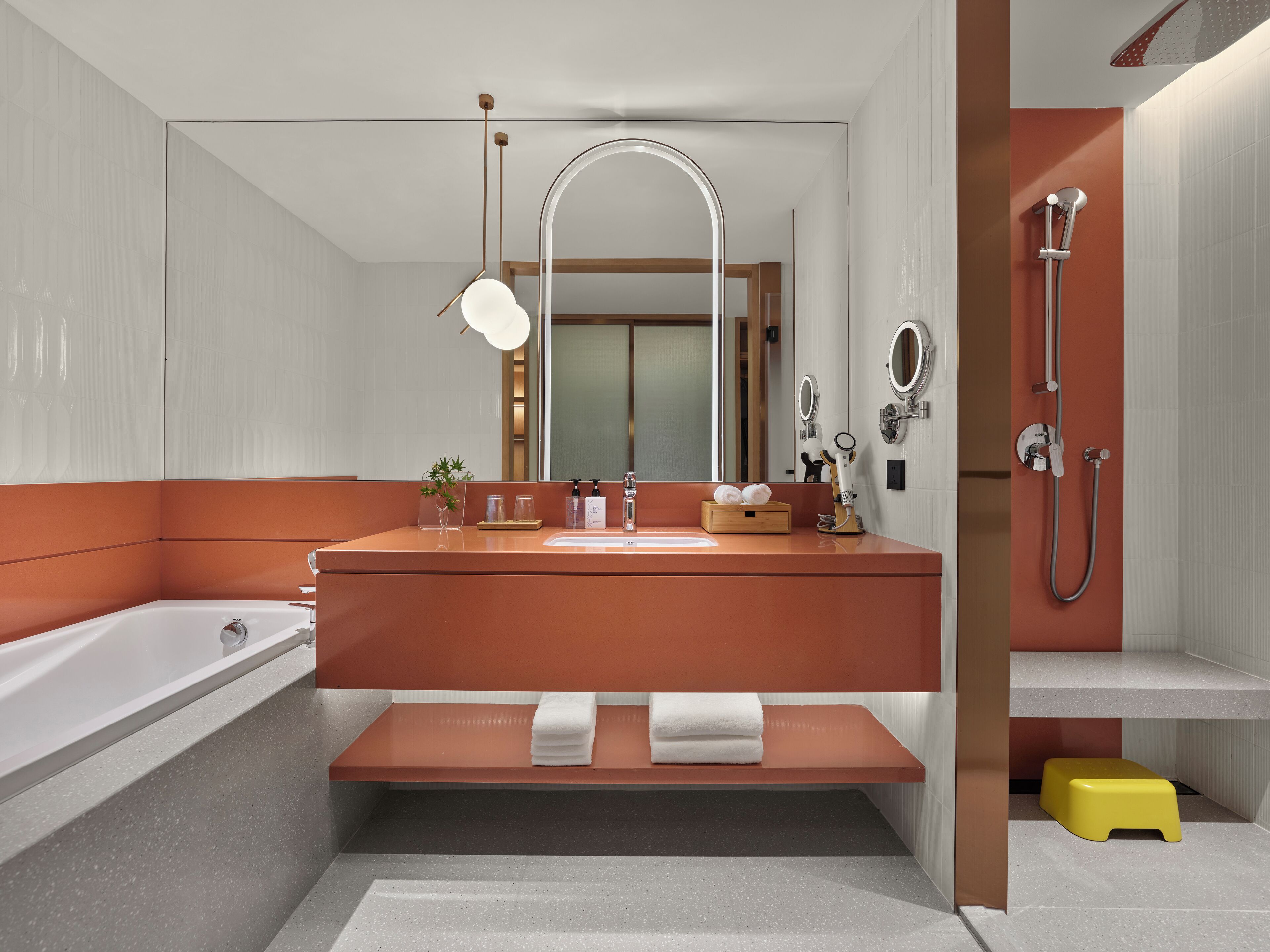Ein modernes Badezimmer mit einem großen Spiegel, einer Badewanne und einer Dusche.