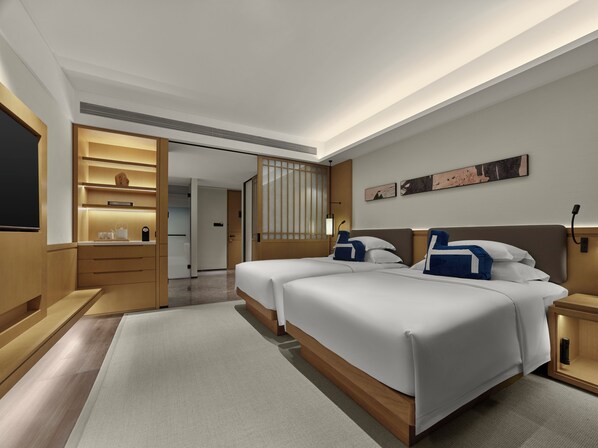 Una habitación de hotel moderna con dos camas, televisor, escritorio y baño.