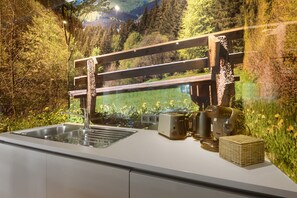 Een keuken met een rvs spoelbak, een broodrooster en een koffiezetapparaat.