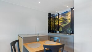 A compact kitchen with a dining area, a view of a forested landscape, and a modern design. - Apartment '2' with Private Terrace, Balcony and Wi-Fi (Schmallenberg)