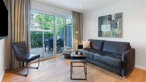 A modern living room with a sofa, a chair, a coffee table, and a painting on the wall. - Apartment '2' with Private Terrace, Balcony and Wi-Fi (Schmallenberg)