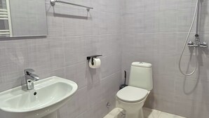 A bathroom with a white sink, toilet, and shower.