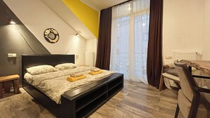 A modern bedroom with a bed, bedside tables, a desk, and a window with curtains.