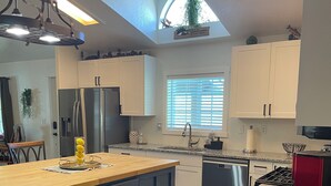 A modern kitchen with a central island, built-in appliances, and a skylight.