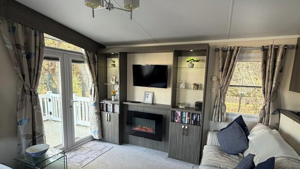 Ein Wohnzimmer mit Kamin, Fernseher und einer Couch.