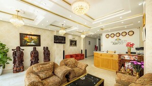 A hotel lobby with patterned sofas, a reception desk, and decorative statues. - AM MEMORY CENTRE HOTEL (Xuan Huong - Da Lat)