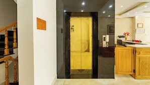 A hotel lobby with a staircase, a reception desk, and a kitchen area. - AM MEMORY CENTRE HOTEL (Xuan Huong - Da Lat)