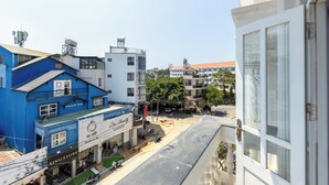 A street view with buildings, including a blue building with a sign that reads "SING STORE". - AM MEMORY CENTRE HOTEL (Xuan Huong - Da Lat)