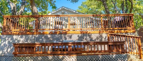 A wooden deck with a lattice fence and a house in the background.