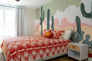 A bedroom with a bed, a nightstand, and a wall mural. - 3BR Saint Jo Getaway | BBQ, Fire Pit + Comfort (Saint Jo)