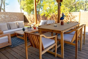 An outdoor wooden deck with a sofa, chairs, and a table. - 3BR Saint Jo Getaway | BBQ, Fire Pit + Comfort (Saint Jo)