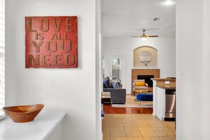 A modern living room with a fireplace, a dining area, and a kitchen. - Pet-Friendly Retreat | Yard, Grill + Workspace (McKinney)