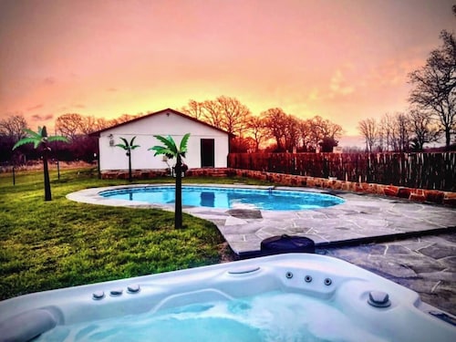 Spacious 4BR ranch for up to 13 on 5 private acres near Saint Jo wineries. Features a pool, hot tub, firepit, chef’s kitchen, wine lounge, Smart TV, and pet-friendly options—perfect for family trips and wine weekends.