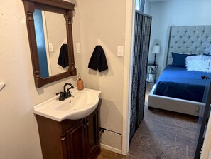 A bathroom with a sink, mirror, and towel rack.