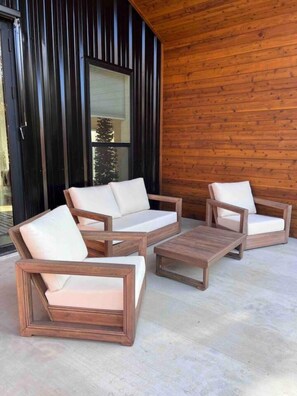 Um deck de madeira com um conjunto de sofá e uma mesa de centro.
