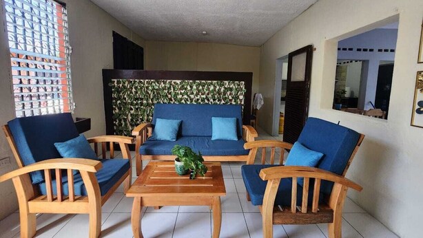 A room with a wooden sofa set, two armchairs, and a coffee table. - 3-bedroom Meraki House in delightful Granada with WiFi (Granada)