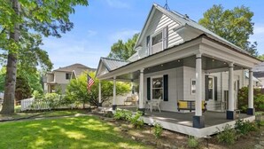 A two-story house with a covered porch, a flag, and a well-maintained lawn. - Enjoy the beautiful waters of Lake Couer d Alene all summer long! Only a few dates left in August and September!  Book now and enjoy all Cd'A has to offer!<br>A historically charming, newly renovated home in the heart of downtown Couer d Alene! (Couer d Alene)