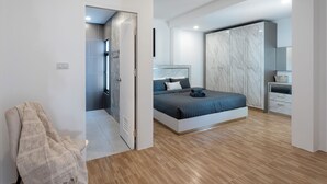 Une chambre moderne avec un lit, une armoire et un espace douche.