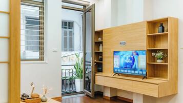 Deluxe-huoneisto, 1 suuri parisänky ja vuodesohva, keittiö, kaupunkinäköala | Oleskelualue | 50–tuumainen äly-TV, jossa digitaalikanavat