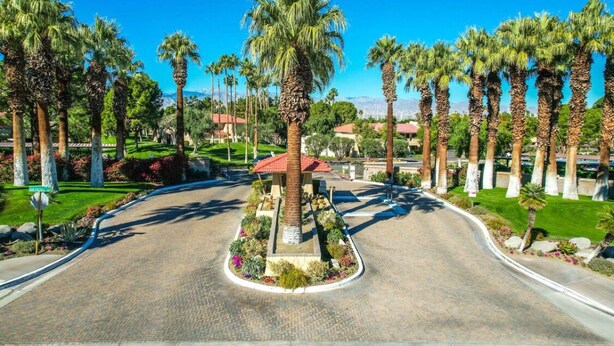 A landscaped area with palm trees and a central gazebo.