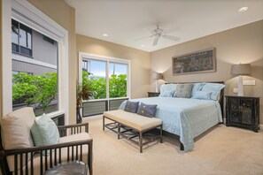 Ein Schlafzimmer mit Bett, Bank, Stuhl und Deckenventilator.