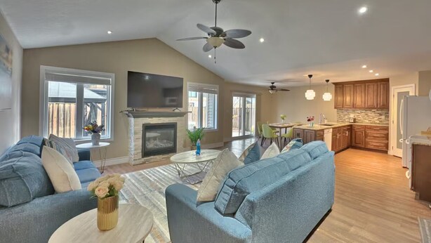 A spacious living area with a fireplace, sofas, and a dining table. - Walk to Grand Bend Main Beach | Sleeps 8 | Family Friendly | Heart of Grand Bend (Grand Bend)