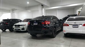 Een parkeergarage met vier auto's op een rij.