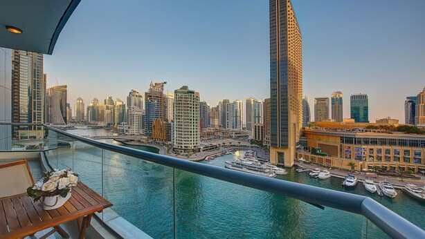 Un balcon offrant une vue sur les toits d’une ville et un port de plaisance.
